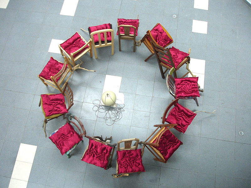 Jeu des chaises (Vu d'en haut) Installation. Chaises, branches de bois, coussins en velours, haut-parleur, son. Dimensions variables