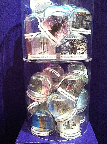 Bons baisers Installation. Tube en plexiglas, boules magiques, photos. 75 x 30 cm